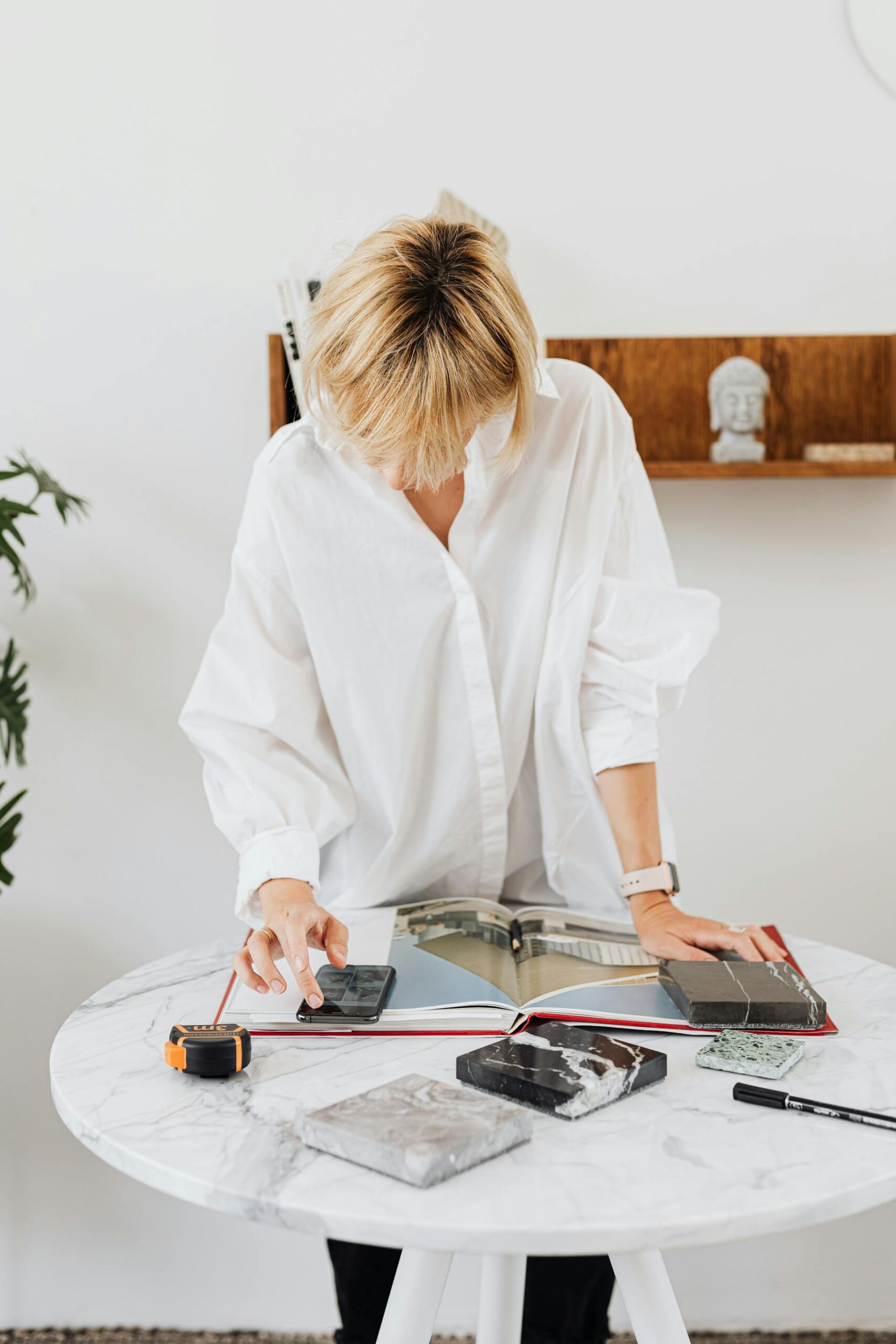 Woman working in her "zone of genius" as she consults a magazine to make key architecture planning decisions.