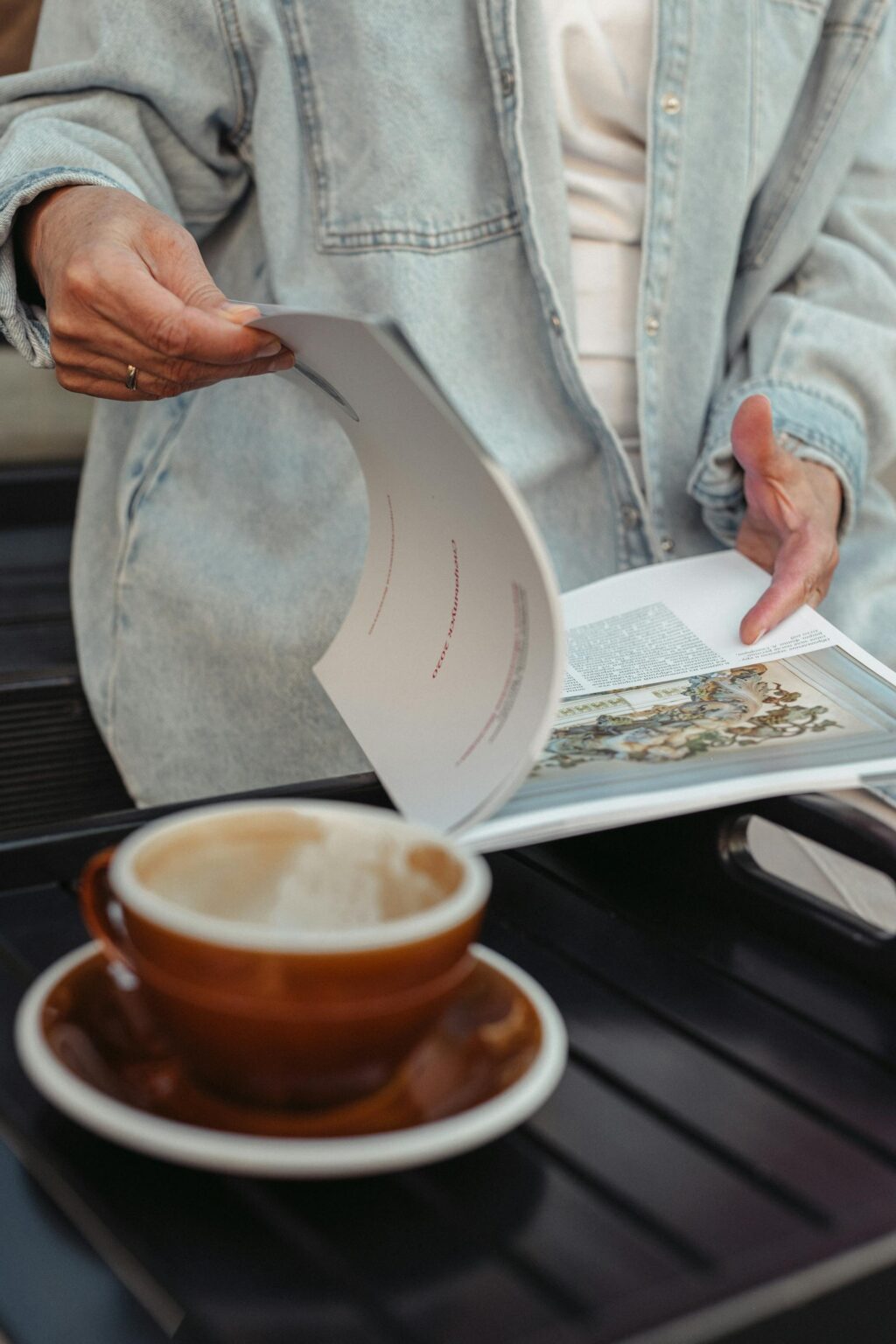 A woman looking at a story in a magazine, preparing to write a media pitch for herself.