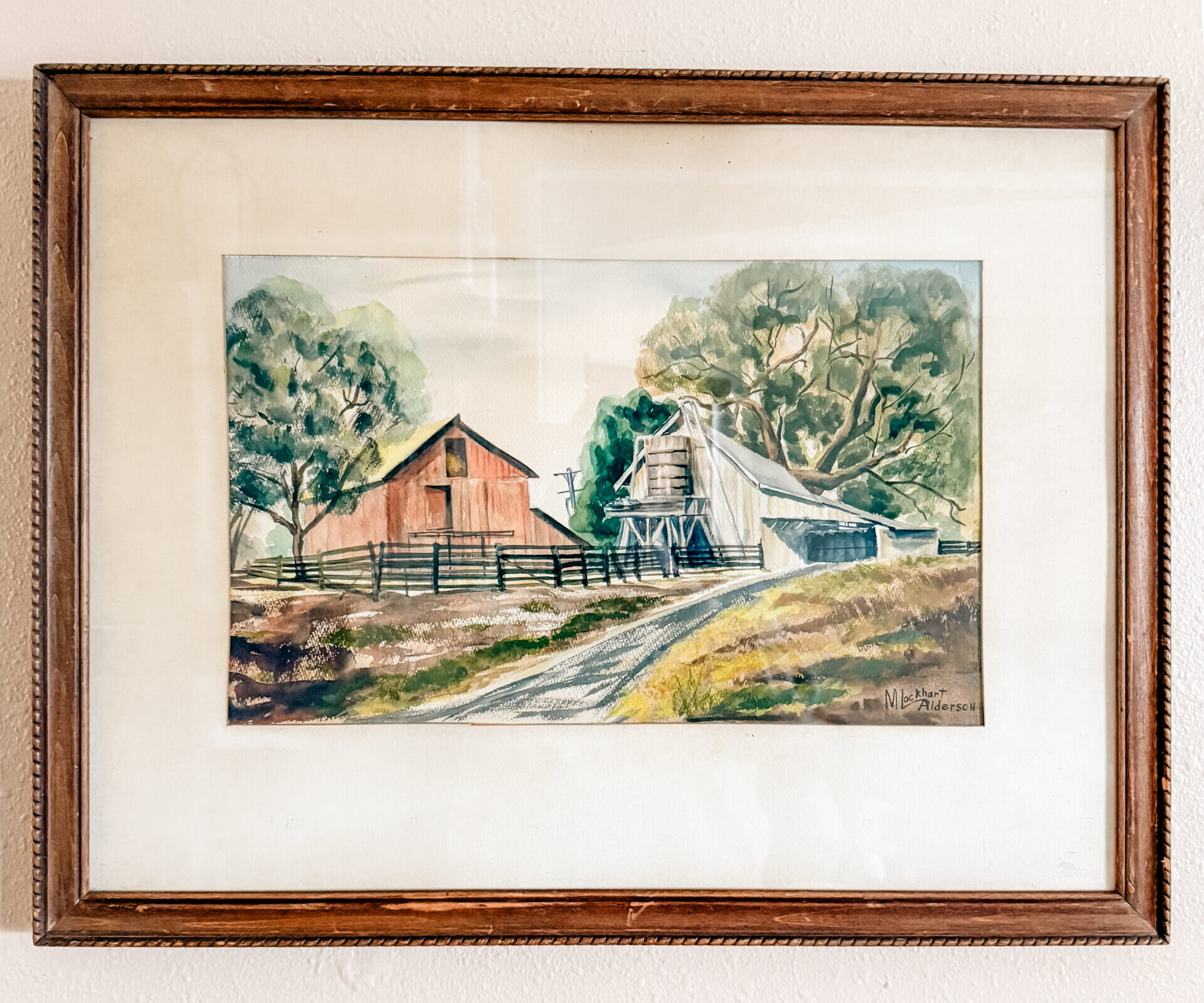 Vintage watercolor painting depicting a barn and an old water tower surrounded by trees, grass, and an old fence.