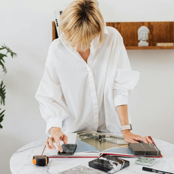 Woman working in her "zone of genius" as she consults a magazine to make key architecture planning decisions.