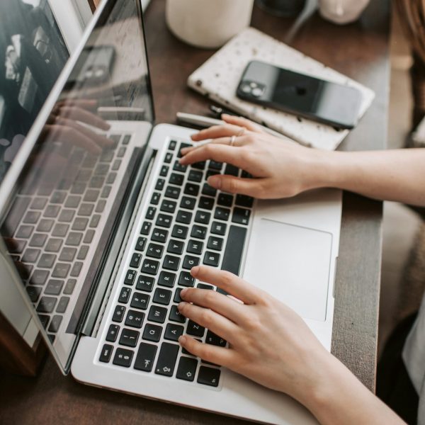 A woman sitting at her laptop writing an email sequence for her list.